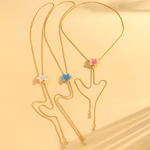 Macro view of adjustable floral enamel necklaces in white, blue, and pink colors