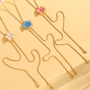 Detailed view of colorful enamel flower pendants on gold-plated adjustable snake chains