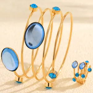 Detail view of French style gold wire-wrapped bracelet and ring set with blue gemstones