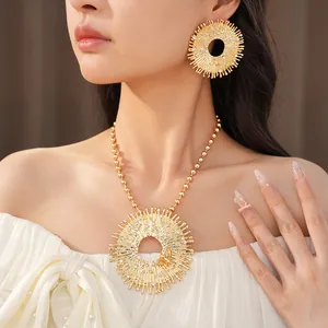 Elegante set di gioielli a raggiera dorata con strass indossato da una modella.
