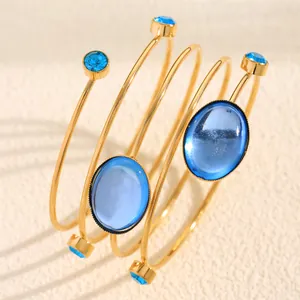 Detailed view of French style gold spiral bracelet with blue gemstones and rhinestones