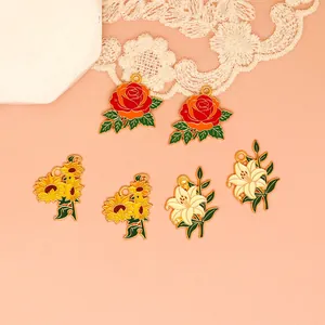 Detailed view of colorful rose, sunflower and lily enamel charms for DIY jewelry making.