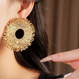 Dettaglio di un orecchino dorato a raggiera con strass scintillanti ed eleganti