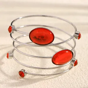 Detail view of multi-layered silver cuff bracelet featuring red oval gems and rhinestones