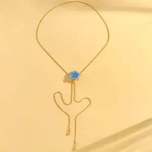 Close-up of blue enamel flower pendant on adjustable gold-plated snake chain