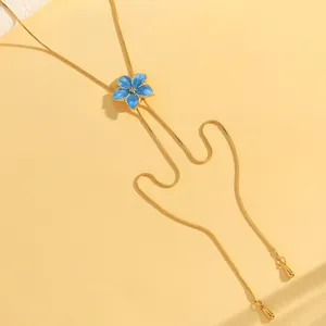 Elegant gold necklace featuring a blue enamel flower pendant on a pale yellow backdrop