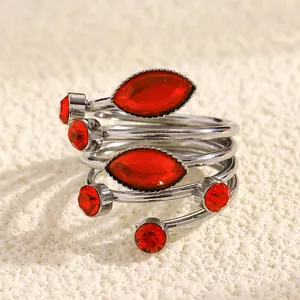 Macro view of a silver-toned spiral ring featuring vibrant red marquise-cut gemstones.