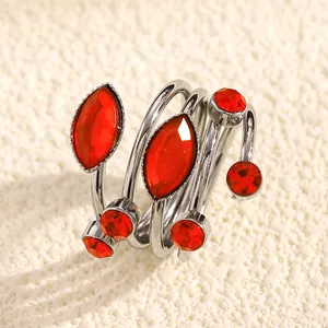 Macro detail view of a French style winding ring with vibrant red faceted gemstones