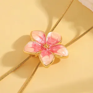 Close-up of pink floral enamel pendant on elegant gold-tone adjustable chain necklace