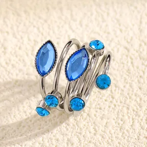 Close-up of elegant blue gemstone spiral ring with navette and round crystals detail