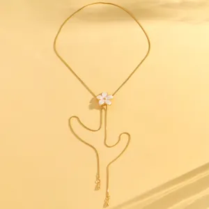 Macro view of a delicate white flower enamel pendant on a gold adjustable snake chain.
