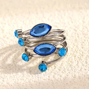 Close-up of French style spiral ring with blue marquise gemstones and crystals