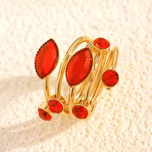 Close-up of gold-plated wrap ring with red marquise and round gemstones