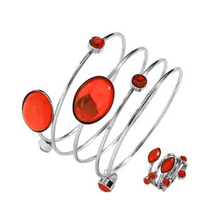 Close-up view of a stylish red gemstone spiral bangle and matching adjustable ring set