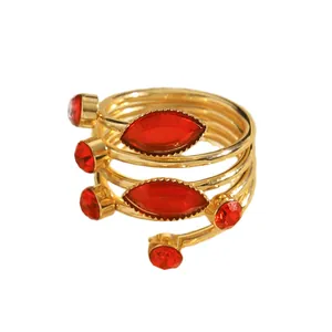 Close-up of gold-plated wrapped ring with red marquise rhinestones and open design.