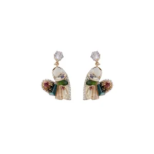 Orecchini a cuore in cristallo arcobaleno con zirconi scintillanti su sfondo bianco.