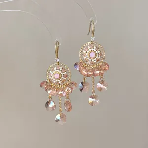 Boucles d'oreilles fleuries style palais vintage avec pompons en cristal rose doré.