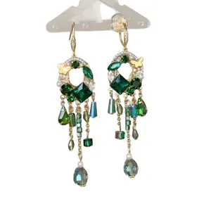 Boucles d'oreilles pendantes style vintage avec pompons en cristal vert et papillons.