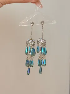 Vue détaillée de boucles d'oreilles de style palais avec de jolies pampilles bleues.