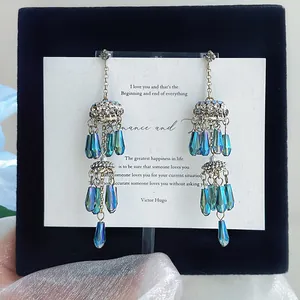 Détail de boucles d'oreilles style palais vintage avec perles bleues irisées