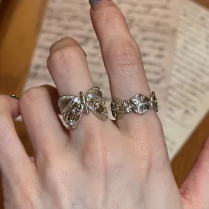 Detailed close-up showing vintage coffee gold butterfly and iris pattern open rings on hand