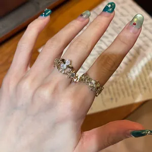Close-up of vintage coffee gold fleur-de-lis and cross rings on hand
