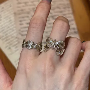 Close-up of vintage coffee gold butterfly and iris patterned open rings worn on hand