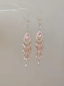 Détail de boucles d'oreilles style palais vintage avec pampilles en cristal rose
