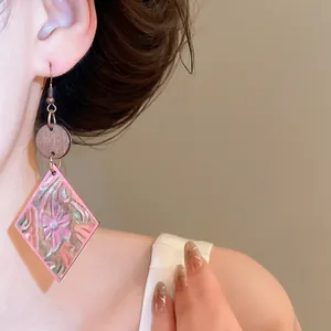 Primer plano detallado del estampado floral en pendientes colgantes de madera en rombo