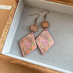 Vista detallada de pendientes étnicos de madera con colgantes romboidales de flores