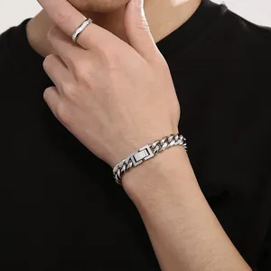 Gros plan d'un bracelet gourmette et d'une bague en acier inoxydable sur un modèle