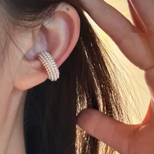 Detailed close-up showing a vintage multi-layered white pearl C-shaped ear cuff on a model