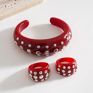 Dettaglio del set di gioielli in resina rossa con borchie argentate e cristalli luminosi