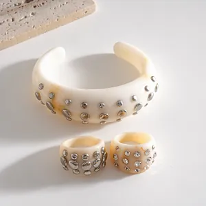 Set di gioielli in resina crema con rivetti metallici inclusi un bracciale e due anelli