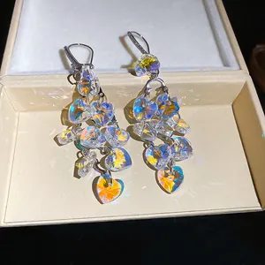 Detailed macro view of elegant heart-shaped crystal tassel drop earrings in a gift box