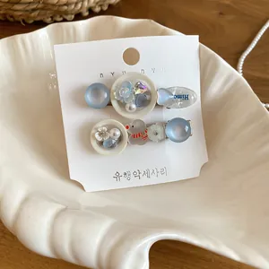 Detailansicht süßer Haarklammern im koreanischen Stil mit blauen Anhängern.