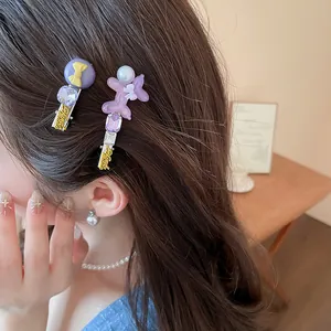 Detailansicht lila Strass-Haarspangen mit Hunde- und Schleifenmotiv im Haar eines Modells