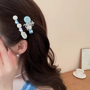 Nahaufnahme von blau-weißen Perlen-Haarspangen mit süßem Hundeanhänger an asiatischem Model