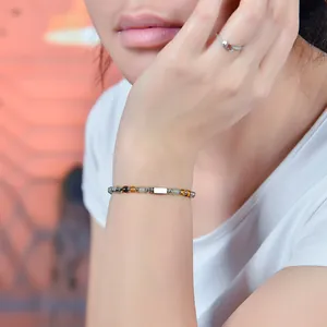 Detaillierte Nahaufnahme eines 4mm Tigerauge und Citrin Perlenarmbands mit Edelstahl