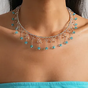 Dettaglio di una collana in pizzo argentato con eleganti frange in cristallo azzurro.