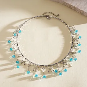 Dettaglio ravvicinato di collana girocollo argentata con frange di cristallo blu chiaro