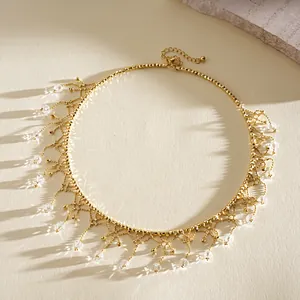 Dettaglio di un girocollo dorato con delicate decorazioni a frange di cristallo.