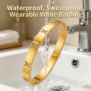 Detail van een gouden armband met klavertje vier onder water, waterdicht ontwerp.