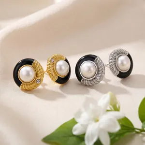 Vue détaillée de boucles d'oreilles élégantes en or et argent avec émail noir et perles
