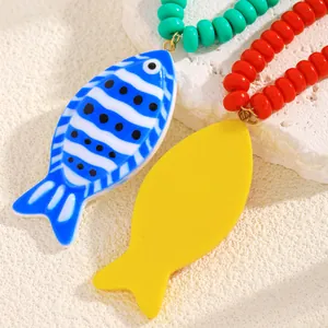 Détail macro des pendentifs de poissons tropicaux et collier de perles colorées