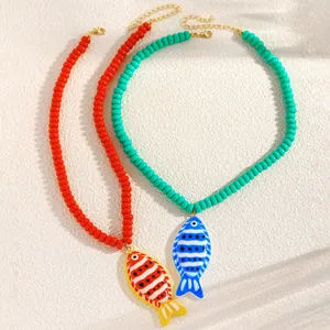 Détail de colliers en perles rouges et turquoise avec pendentifs poissons tropicaux