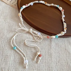 Detail of a bohemian braided waist chain with colorful beads and natural shell accents