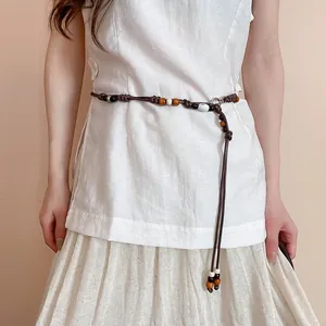 Detail view of a Bohemian retro beaded waist rope belt styled on a white linen tunic