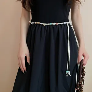 Close-up view of a Bohemian vintage beaded waist chain on a black dress accessory