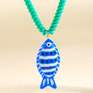 Vue détaillée d'un collier pendentif poisson bleu tropical avec perles vertes style océan